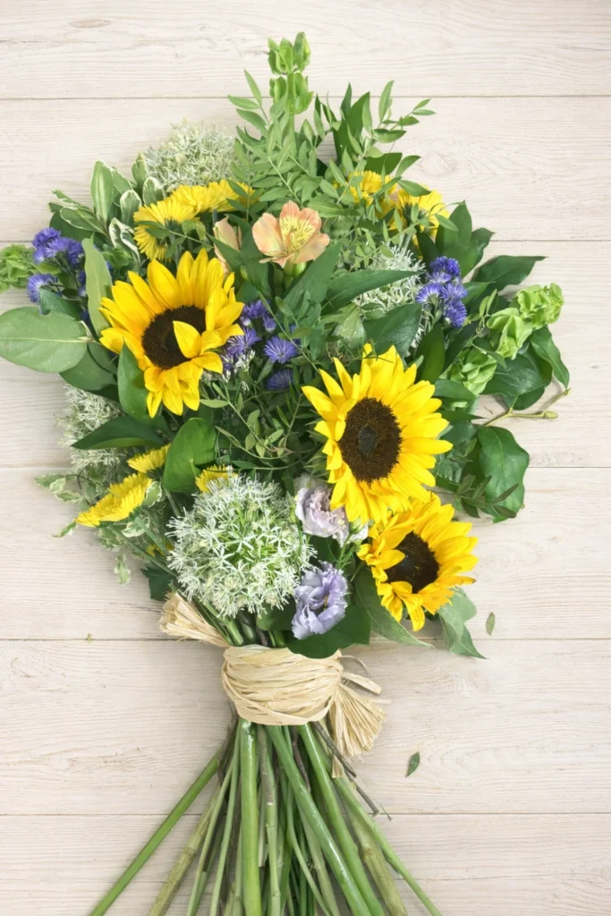 Handtied Spray wit sunflowers, beautiful yellow & purple funeral flowers, ideal for a woodland funeral